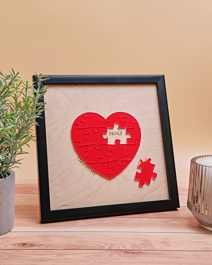 Image du cadre puzzle coeur rouge de Saint-Valentin mettant en scène ses pièces de puzzle élégamment agencées pour former un cœur, avec une pièce latérale révélant une date spéciale. Personnalisable avec prénoms et date, ce cadre puzzle symbolise l’amour authentique et l’émotion partagée.